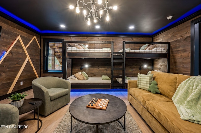 interior space featuring a notable chandelier, wooden walls, and wood finished floors