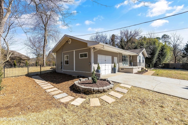 view of front facade with an attached garage, covered porch, fence, driveway, and a front yard