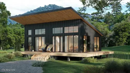 back of house featuring board and batten siding and a yard