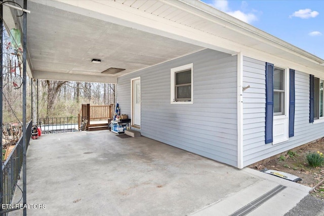 view of patio featuring an attached carport and fence