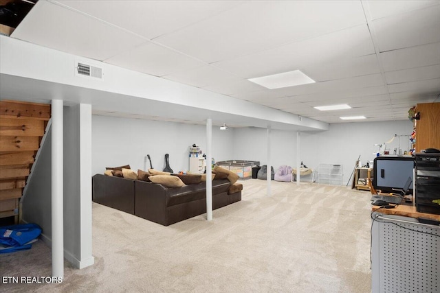 finished basement with carpet, a paneled ceiling, and visible vents