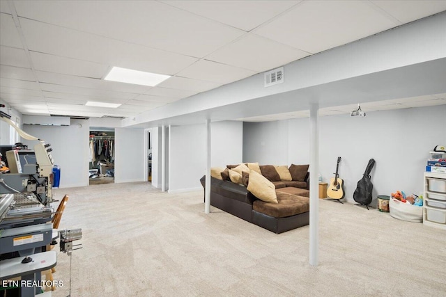 finished basement with visible vents, a paneled ceiling, and carpet floors