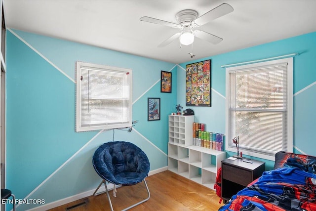 bedroom featuring multiple windows, wood finished floors, visible vents, and baseboards