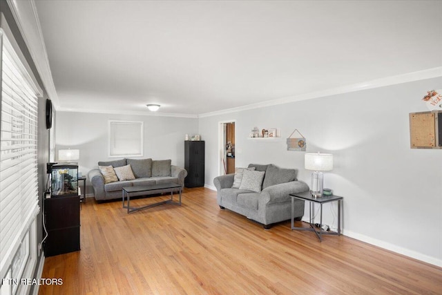 living room with light wood-type flooring, baseboards, and crown molding