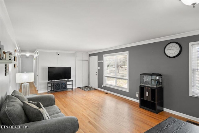 living area featuring crown molding, wood finished floors, visible vents, and baseboards