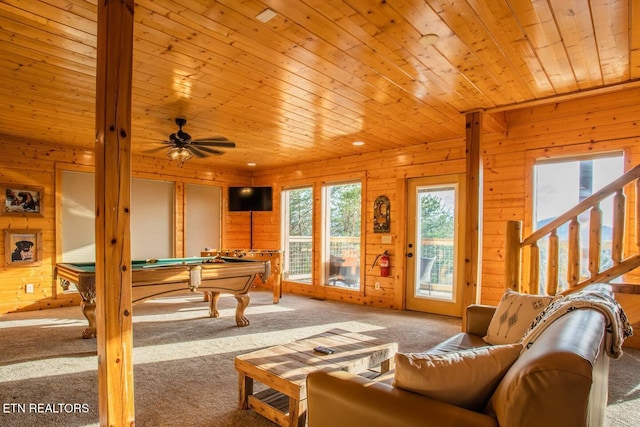 carpeted living area with pool table, stairway, a ceiling fan, wooden walls, and wooden ceiling