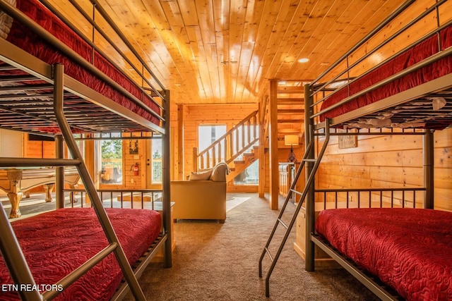 carpeted bedroom featuring wood ceiling and wooden walls