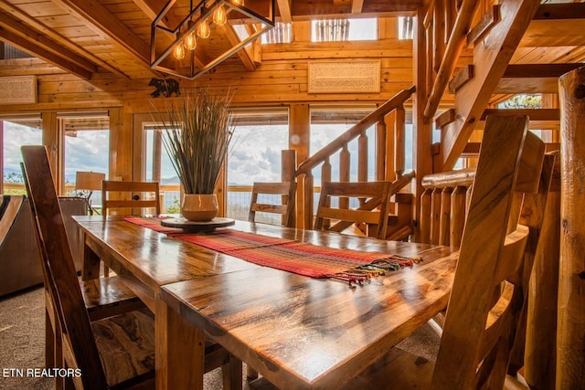 dining room featuring vaulted ceiling with beams, stairway, wood ceiling, and wooden walls