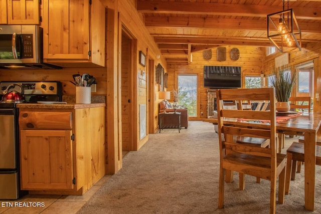 dining room with beam ceiling, wood walls, wood ceiling, and light colored carpet