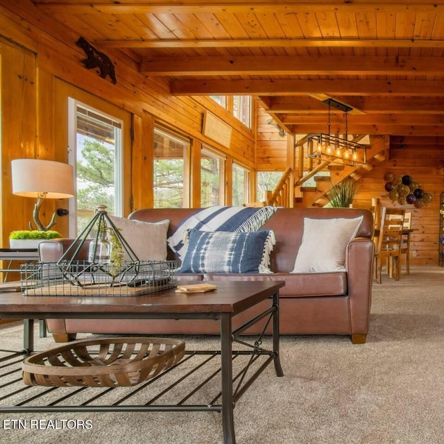 living area featuring stairway, wood ceiling, carpet flooring, wooden walls, and beamed ceiling