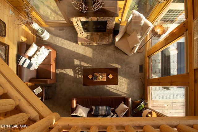 interior space featuring visible vents, a notable chandelier, and a stone fireplace