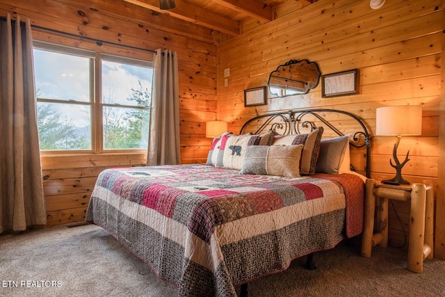 carpeted bedroom featuring wood walls and beam ceiling