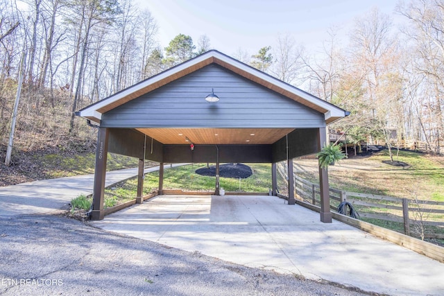 view of car parking with a carport and fence