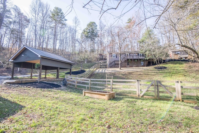 view of yard with stairway, a garden, fence, and a wooden deck