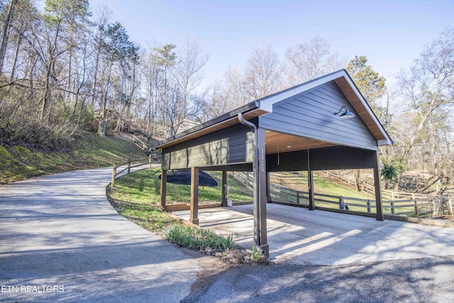 surrounding community with a carport, driveway, and fence