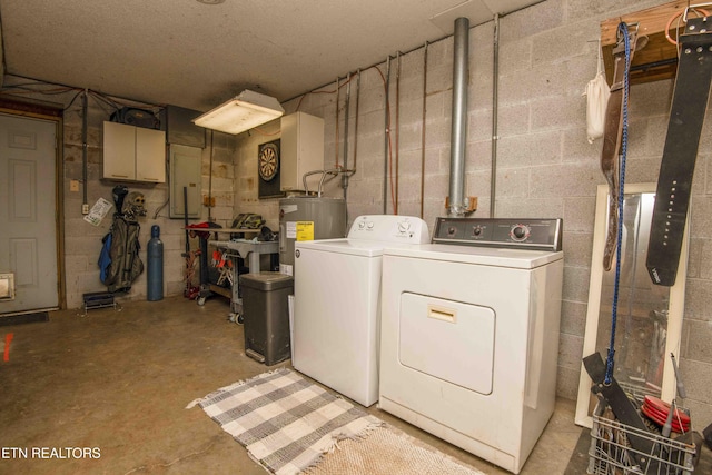 clothes washing area featuring laundry area, concrete block wall, washing machine and dryer, and water heater