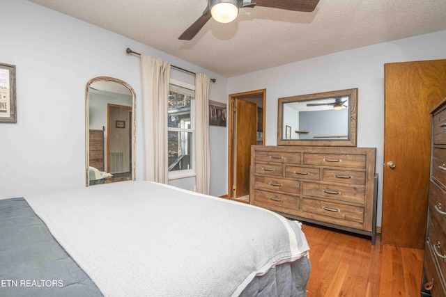 bedroom with a textured ceiling, wood finished floors, and a ceiling fan