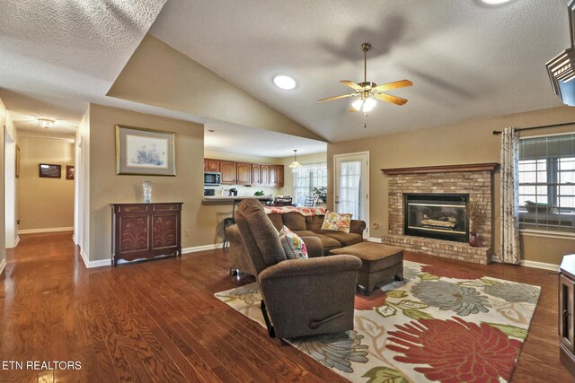 living room with a fireplace, lofted ceiling, dark wood-style floors, and baseboards