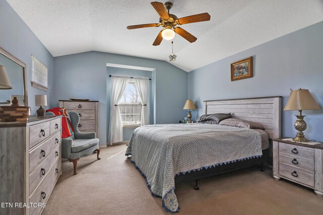 bedroom featuring a ceiling fan, lofted ceiling, light colored carpet, and a textured ceiling