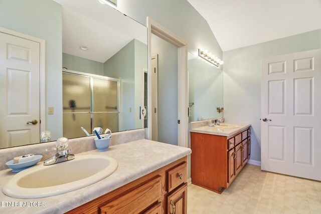 bathroom featuring tile patterned floors, lofted ceiling, a stall shower, and vanity