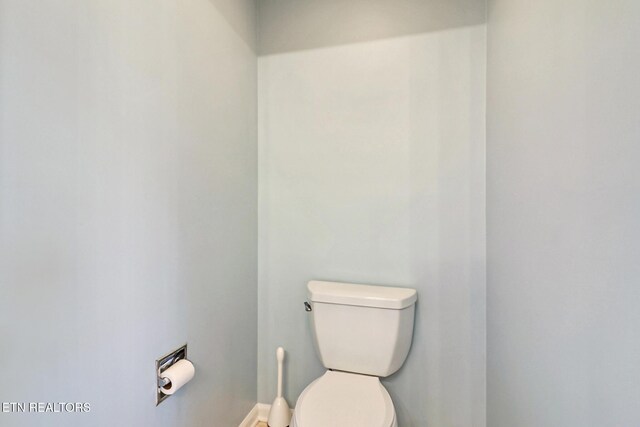 bathroom featuring toilet and baseboards