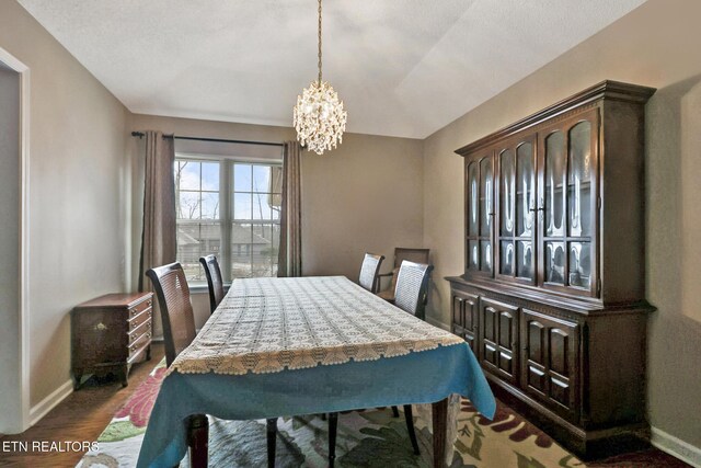 dining area featuring baseboards, a chandelier, and dark wood-style flooring