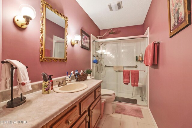 bathroom with visible vents, toilet, a shower stall, tile patterned flooring, and vanity