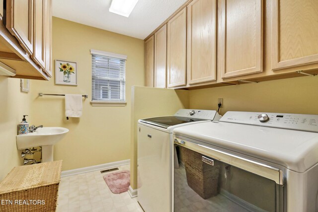 washroom featuring visible vents, baseboards, light floors, cabinet space, and independent washer and dryer