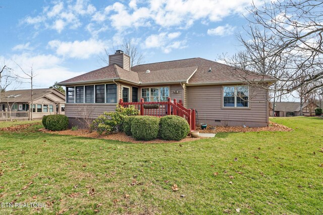 rear view of house featuring a lawn, a sunroom, a shingled roof, crawl space, and a chimney