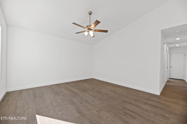 empty room featuring vaulted ceiling, wood finished floors, a ceiling fan, and baseboards