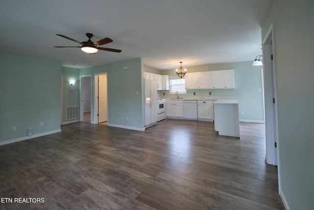 kitchen with white appliances, visible vents, open floor plan, and a sink