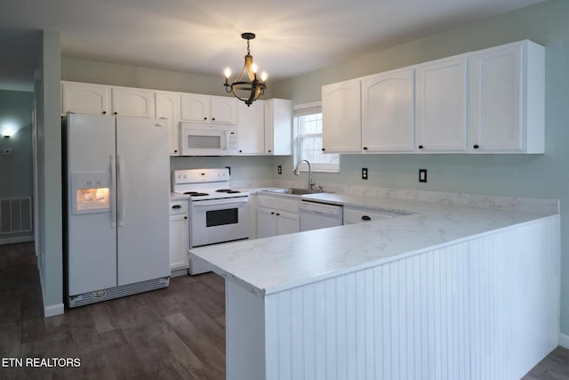 kitchen with visible vents, white cabinetry, a sink, white appliances, and a peninsula