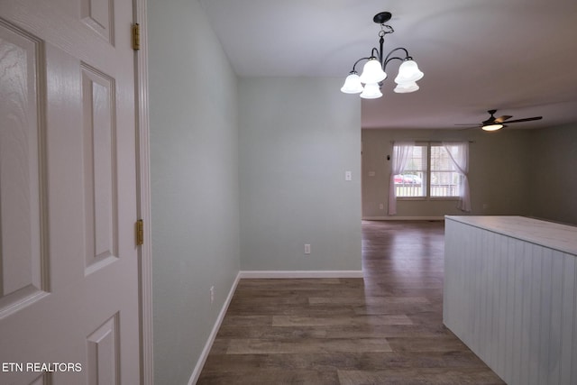 interior space with baseboards, a chandelier, and dark wood-style flooring