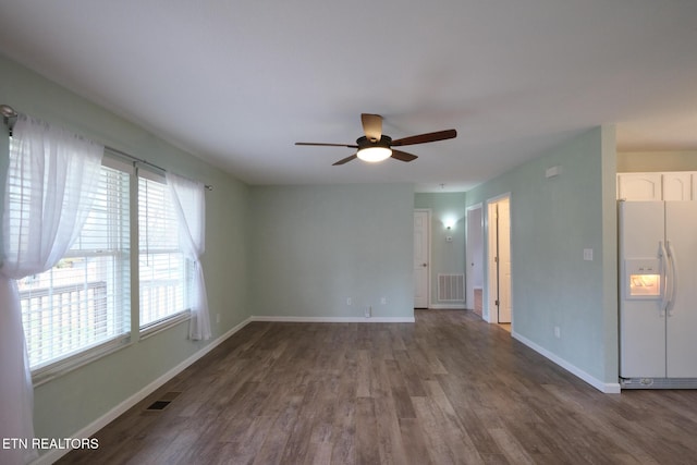 unfurnished room with a ceiling fan, baseboards, visible vents, and dark wood-style flooring