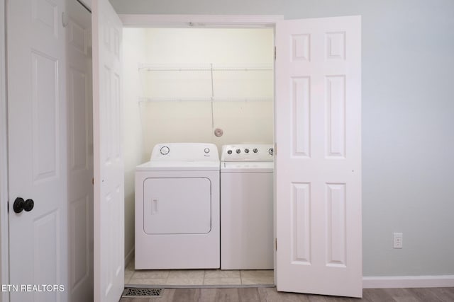 washroom with laundry area, baseboards, and washing machine and clothes dryer