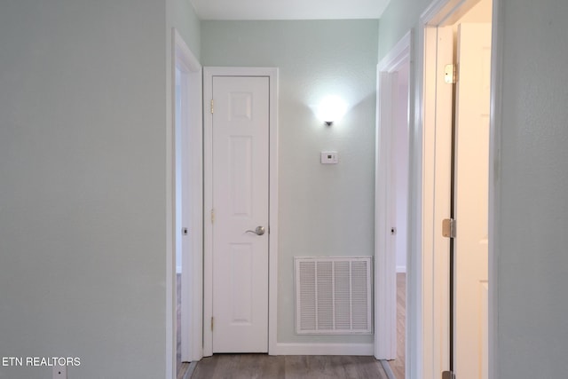 corridor featuring wood finished floors and visible vents