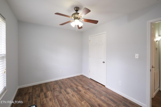 unfurnished bedroom featuring ceiling fan, dark wood-style flooring, and baseboards