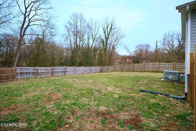 view of yard with a fenced backyard and central AC unit