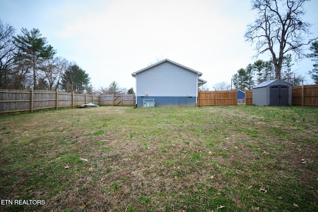 view of yard featuring a storage shed, an outdoor structure, a fenced backyard, and central air condition unit