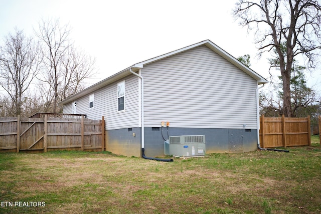 back of property with crawl space, central air condition unit, fence, and a yard