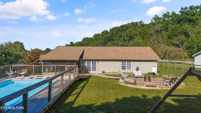 back of property featuring a fenced in pool, a lawn, a deck, and fence