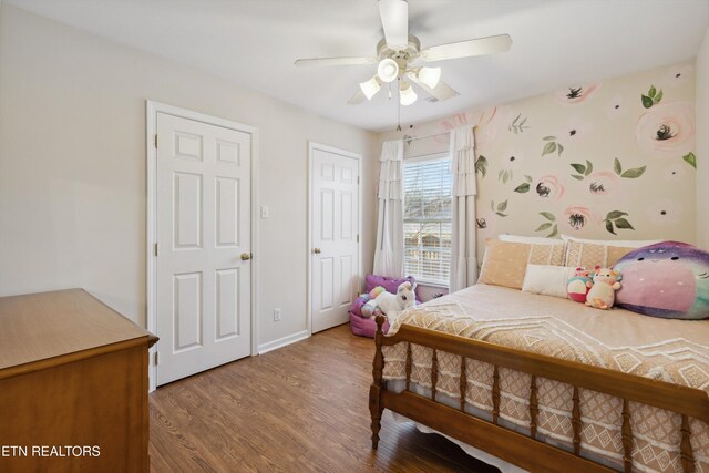 bedroom featuring a ceiling fan, wood finished floors, and baseboards