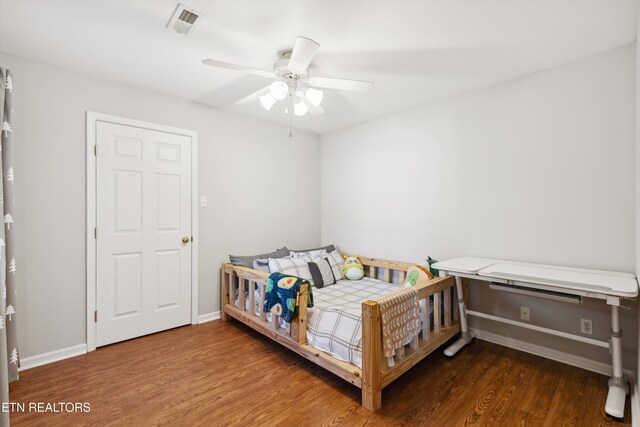 bedroom with visible vents, wood finished floors, baseboards, and ceiling fan