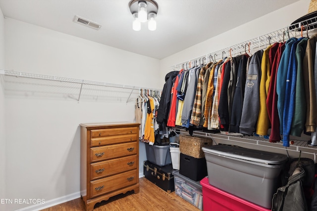 walk in closet with wood finished floors and visible vents