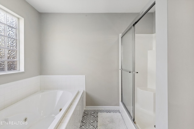 bathroom featuring tile patterned floors, baseboards, a stall shower, and a whirlpool tub