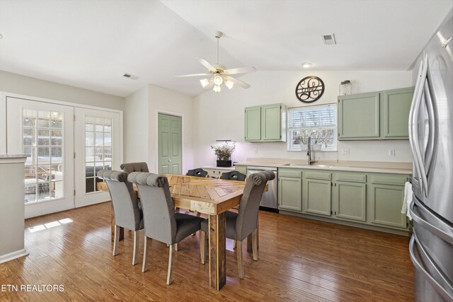 dining space featuring dark wood-style floors, visible vents, a ceiling fan, and vaulted ceiling