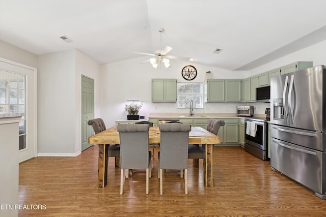 kitchen featuring green cabinetry, stainless steel appliances, dark wood-type flooring, and visible vents