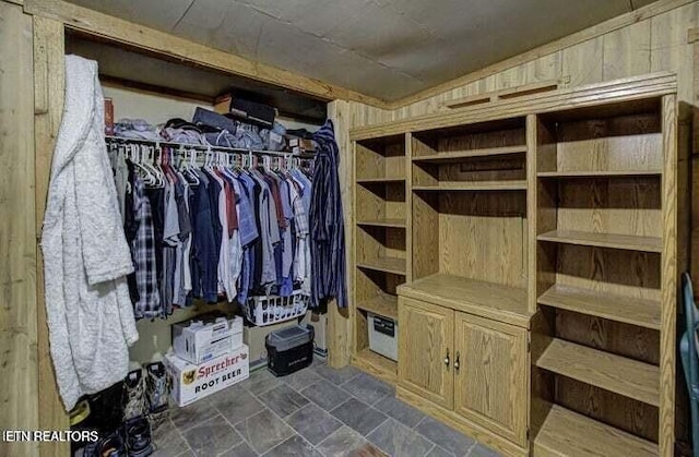 spacious closet featuring stone finish flooring