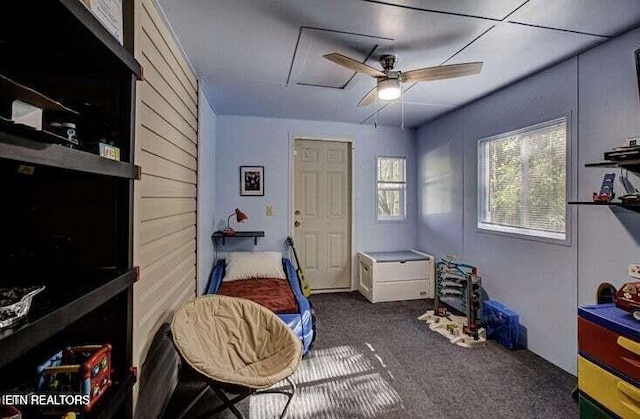 carpeted bedroom featuring attic access and ceiling fan