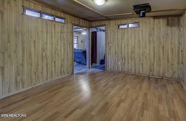 unfurnished room featuring wood walls and wood finished floors